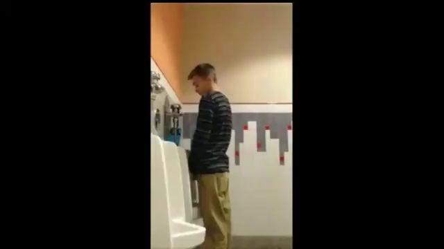 A male is pissing in the toilet 10.